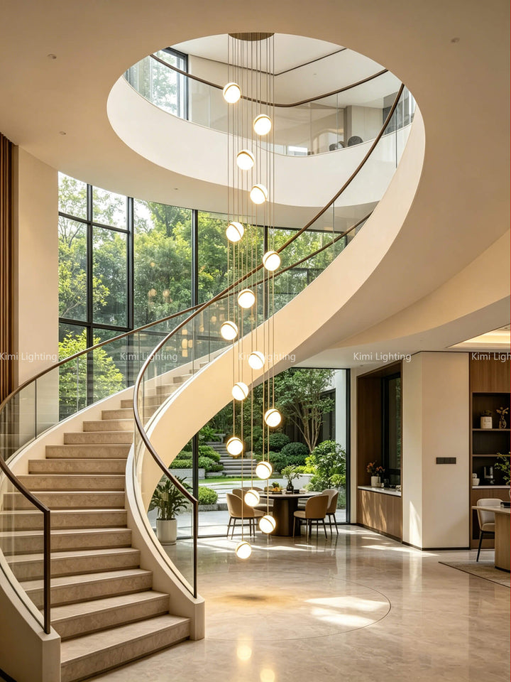 A luxury gold glass pendant lighting fixture hangs in center of bright spiral staircase.