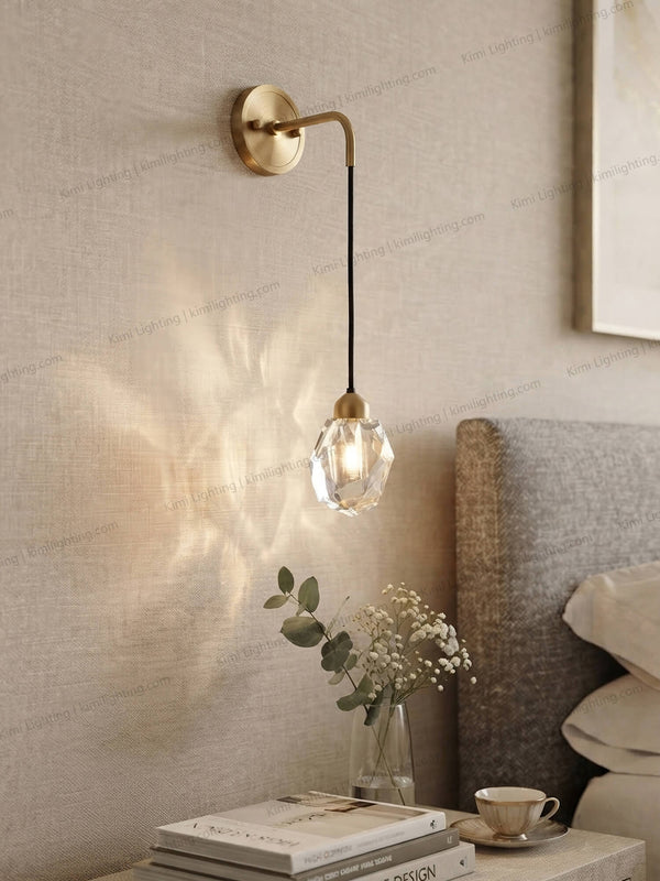 Modern crystal wall sconce adds elegant lighting beside a bedroom bed.
