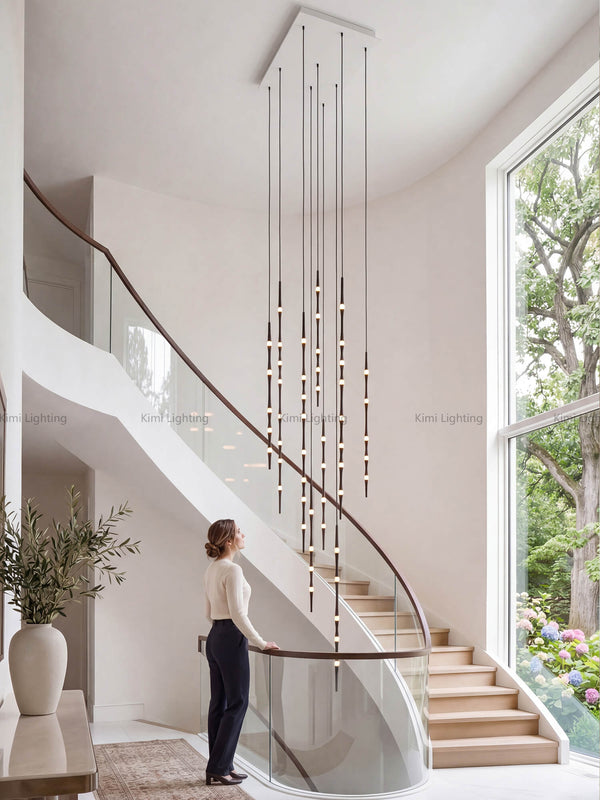 Dew drop chandelier in a modern high-ceiling stairwell with fluid organic modern style.