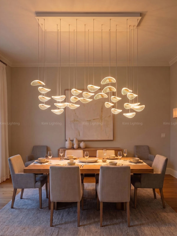 Modern gold rectangular chandelier over a long dining table offers bright cost-effective unique dining lighting.