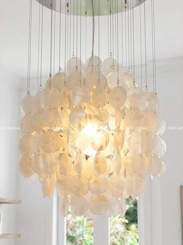 Layered capiz shell chandelier in an open great room with grand and natural luxury style.